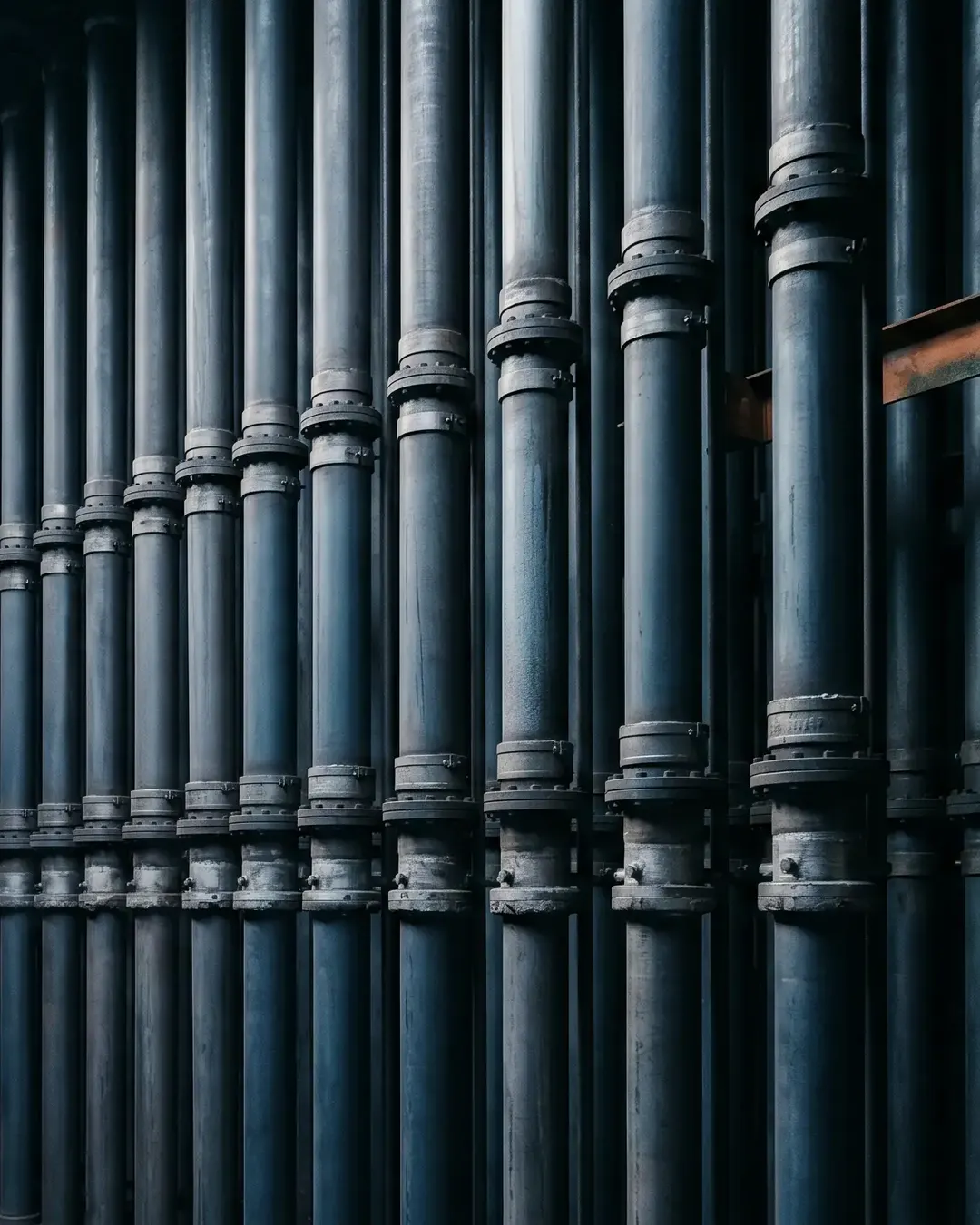 Rows of tall vertical reformer furnace tubes receding into shadow