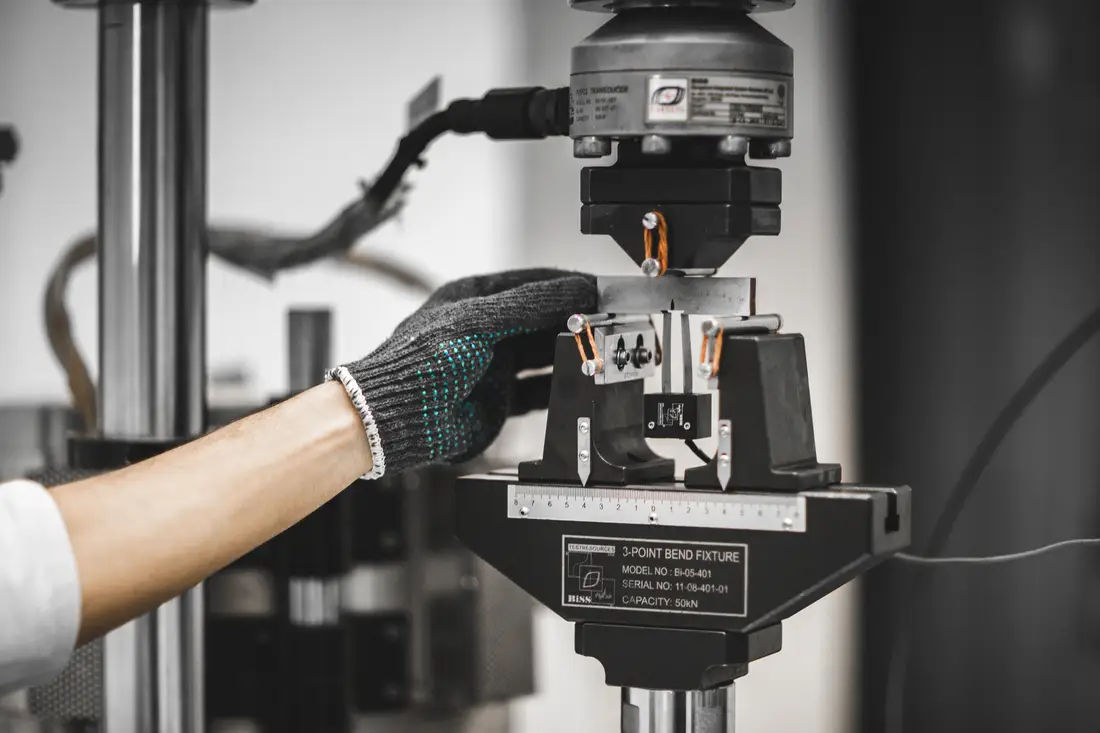 A servo-hydraulic fatigue frame at TCR Engineering running a cyclic test on a machined specimen