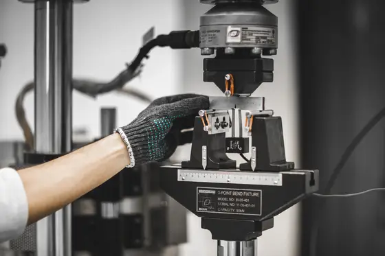 A servo-hydraulic fatigue frame at TCR Engineering running a cyclic test on a machined specimen