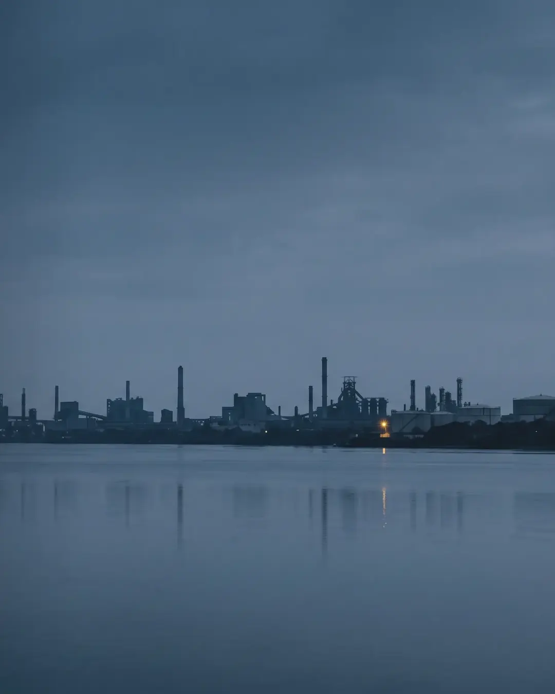The Navi Mumbai industrial skyline at dusk seen across a tidal creek