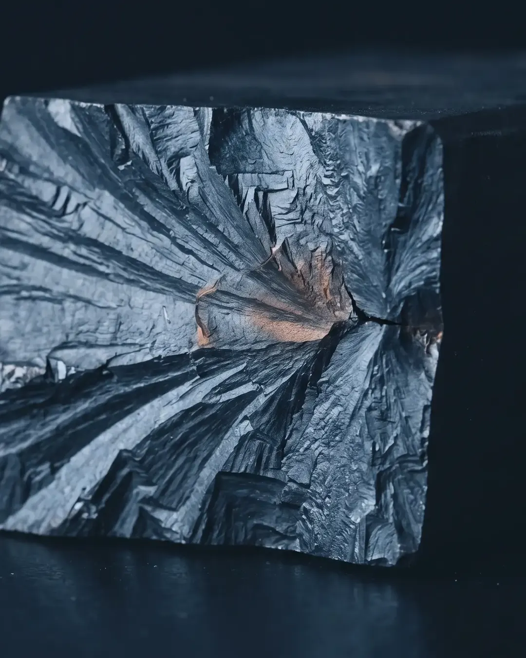 A single cleavage fracture surface at macro scale, river patterns radiating from an origin
